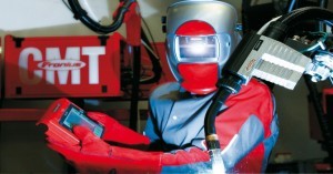 A robot programmer / robot welder uses the touch pendant of a Fronius CMT welding power unit.